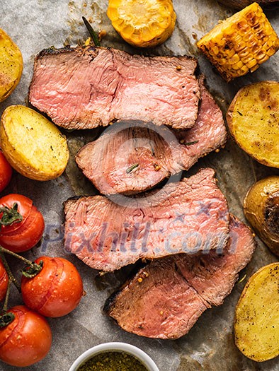 Sliced Roast beef on cutting board with grilled vegetables Sliced Roast beef on cutting board with grilled vegetables
