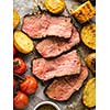 Sliced Roast beef on cutting board with grilled vegetables 