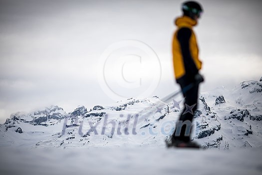 Skier skiing downhill in high mountains