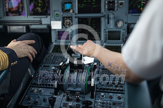 Pilot's hand accelerating on the throttle in  a commercial airliner airplane flight cockpit during takeoff
