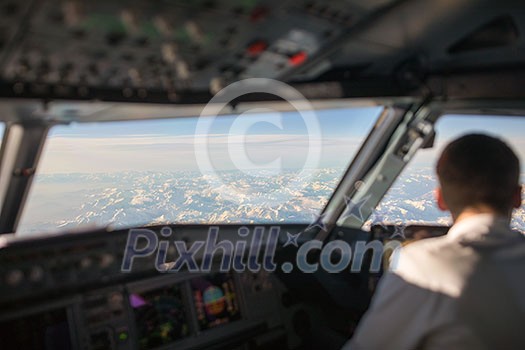 Pilot in a commercial airliner airplane flight cockpit during flight Pilot in a commercial airliner airplane flight cockpit during flight