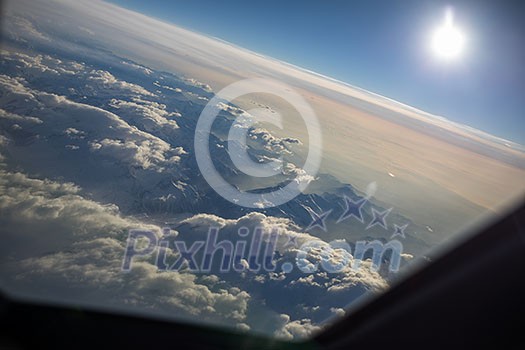 View from a cockpit of a commercial airliner airplane over a beautiful mountain range