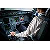 Pilot's hand accelerating on the throttle in  a commercial airliner airplane flight cockpit during takeoff