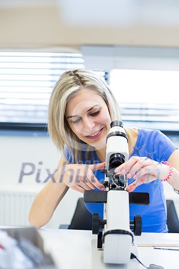 Pretty, female optometrist measuring newly made glasses - veryfing it is spot on