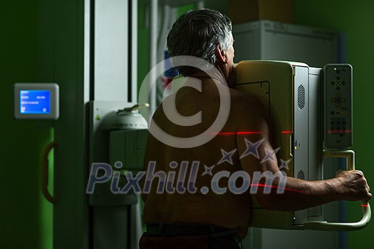 Healthcare Concept - Senior male patient undergoing an X-ray examination in a modern hospital Healthcare Concept - Senior male patient undergoing an X-ray examination in a modern hospital