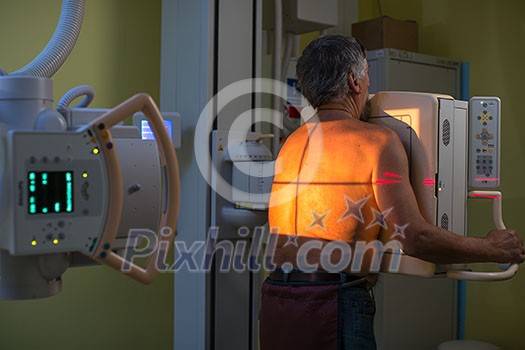 Healthcare Concept - Senior male patient undergoing an X-ray examination in a modern hospital Healthcare Concept - Senior male patient undergoing an X-ray examination in a modern hospital