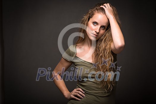 Studio glamour portrait of a pretty, young woman with lovely curly hair