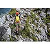 Pretty, female climber on a via ferrata - climbing on a rock in Swiss Alps