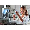 Portrait of a female researcher doing research in a lab, using a tablet computer for data collection and visualization(shallow DOF; color toned image)