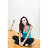 Cute young woman with a racket leaning against a wall in a squash court, ready for the game