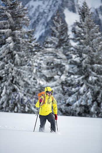 Young man snowshoeing in high mountains, enjoying splendid winter weather with abundance of snow