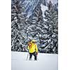 Young man snowshoeing in high mountains, enjoying splendid winter weather with abundance of snow