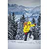 Young man snowshoeing in high mountains, enjoying splendid winter weather with abundance of snow