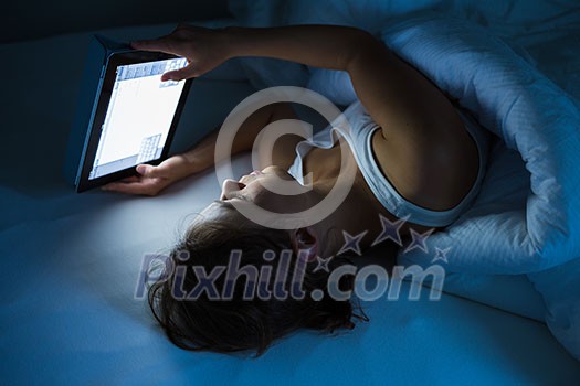 Pretty young woman watching something awful/sad on her laptop in bed