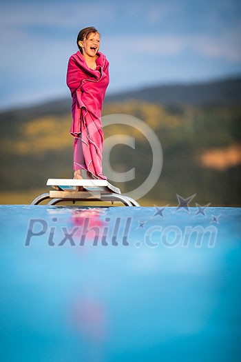 Little girl on a pool's edge, learning to swim and dive. Swimming with kids. Healthy sport activity for children. Sun protection. Water fun.