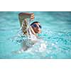 Man swimmer swimming crawl in a blue water  pool. Portrait of an athletic young male triathlete swimming crawl wearing swimming goggles. Triathlete training for triathlon.