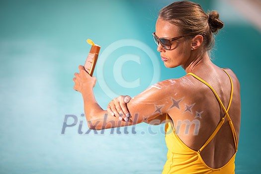 Suncream Concept. Pretty, young woman in a swimsuit is applying sunscreen trying to protect the skin from the harmful effects of sunlight she loves Suncream Concept. Pretty, young woman in a swimsuit is applying sunscreen trying to protect the skin from the harmful effects of sunlight she loves