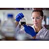 Female researcher carrying out scientific research in a lab (shallow DOF; color toned image)