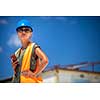 Female engineer architect with a  safety helmet and a cell phone in a building site planning new commercial residential project