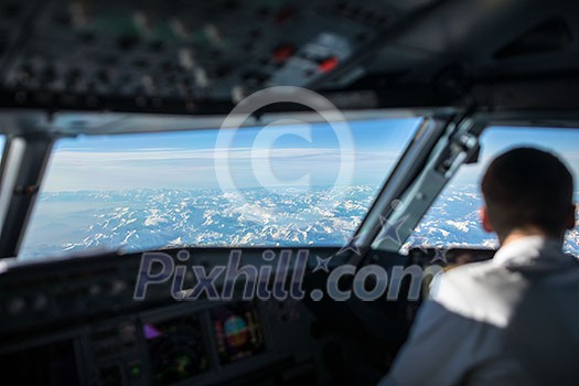 Pilot in  a commercial airliner airplane flight cockpit during flight with great weather