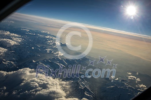 View from a cockpit of a commercial airliner airplane over a beautiful mountain range