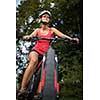 Pretty, young woman riding her mountain bike on a forest path. Enjoying active leisure time outdoors.