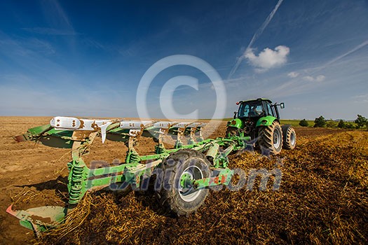 Tractor working on the farm, modern agricultural transport, farmer working in the field, tractor on a sunset background, cultivation of land, agricultural machine