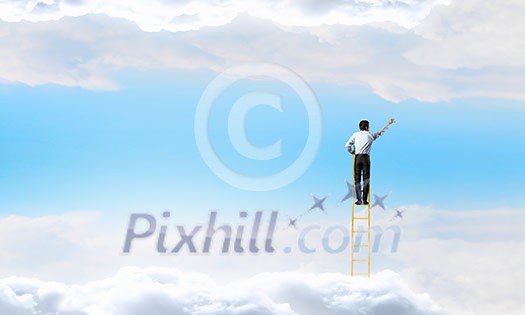Businessman standing on ladder high in blue sky with clouds