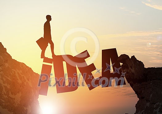 Businessman running on idea word bridge over precipice Businessman running on idea word bridge over precipice