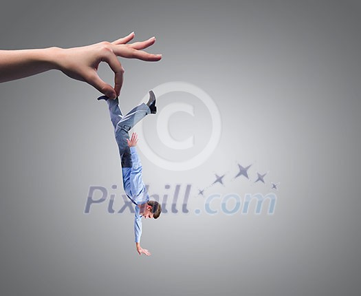 Close up of human hand holding miniature of businessman
