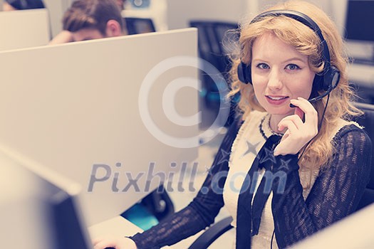 young smiling female call centre operator doing her job with a headset young smiling female call centre operator doing her job with a headset