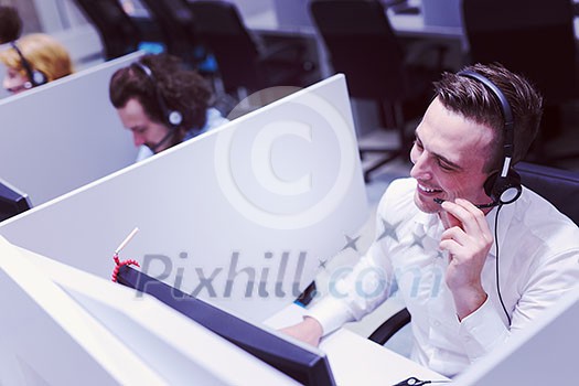 young smiling male call centre operator doing his job with a headset young smiling male call centre operator doing his job with a headset