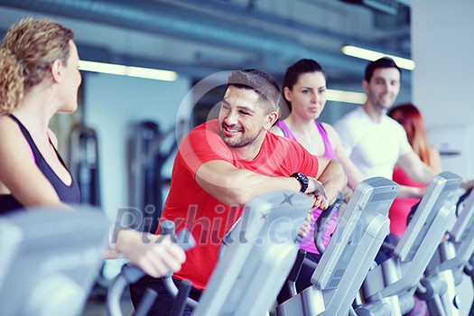 group of young people running on treadmills in modern sport gym group of young people running on treadmills in modern sport gym