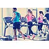 group of young people running on treadmills in modern sport  gym