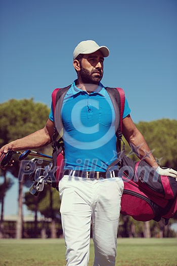 handsome middle eastern golf player carrying bag and walking at course to next hole handsome middle eastern golf player carrying bag and walking at course to next hole