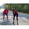 young couple enjoying in a healthy lifestyle while warming up and stretching before running on a country road, exercise and fitness concept