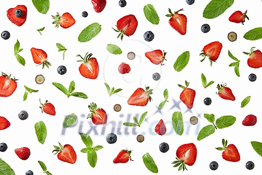 Blueberries halves of ripe strawberries and green mint leaves on a gray background. Pattern of berries, flat lay