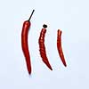 Red chili pepper cut into slices as a version of slicing for cooking on a gray background, top view