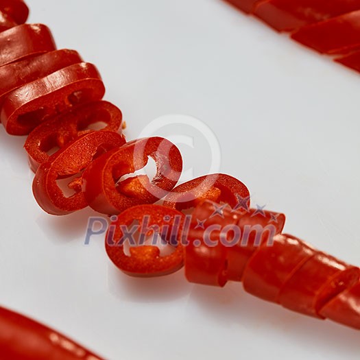 red hot chili pepper or chilli cayenne pepper with sliced pieces on white background. Macro shot
