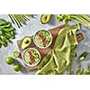 Vegetable green smoothies with flax and kiwi in a plate on an old wooden board with a kitchen towel around a set of vegetables, avocado, cucumber, spinach, asparagus, lime, celery. Healthy Vegetarian Food. Flat lay