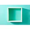 Simple green wood box shelf in the form of a square isolated on a wall of mint color. Product display template