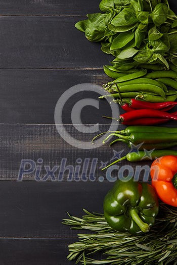 Food background - raw organic vegetables, fresh ingredients for healthily cooking on wooden background with copy space, flat lay. Vegetarian or healthy food