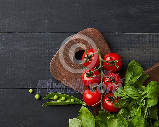 Fresh vegetables and herbs on a dark wooden background. Space for text and flat lay. Vegan concept