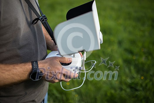 Man Operating a Drone by a Remote Control outdoors Man Operating a Drone by a Remote Control outdoors