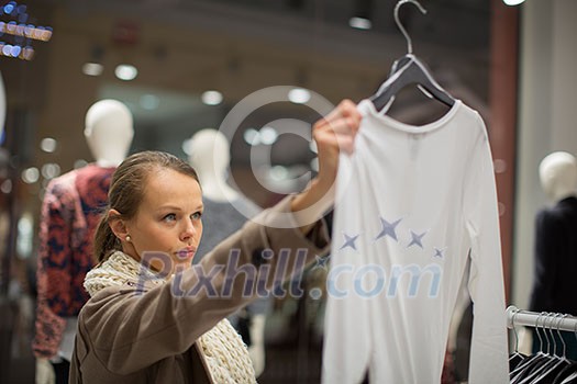 Young woman shopping in a fashion store (color toned image; shallow DOF) Young woman shopping in a fashion store (color toned image; shallow DOF)