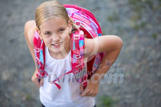 Cute little girl going home from school, looking well before crossing the street
