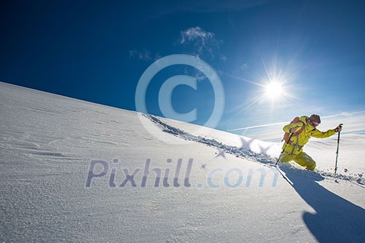 High altitude mountain explorer walking through deep snow in high mountains on a freezing winter day