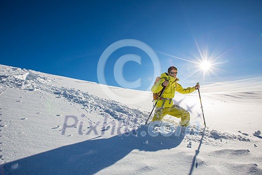 High altitude mountain explorer walking through deep snow in high mountains on a freezing winter day High altitude mountain explorer walking through deep snow in high mountains on a freezing winter day