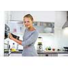 Pretty, young woman cooking in her modern kitchen