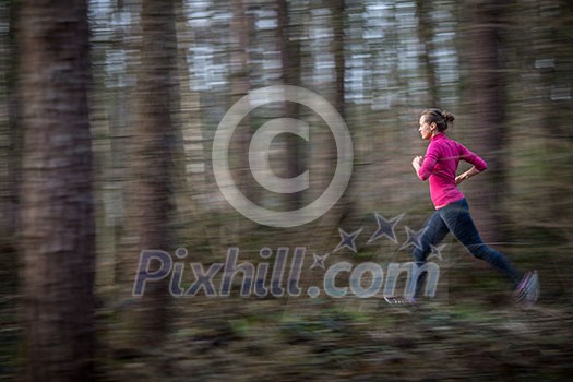 Young woman running outdoors in a forest, going fast (motion blurred image) Young woman running outdoors in a forest, going fast (motion blurred image)